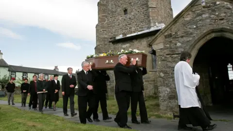 Guzelian A funeral procession carrying the woman's coffin into the church
