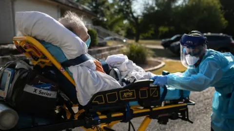 Getty Images An Austin-Travis County medic loads a patient with COVID-19 symptoms into an ambulance on August 05, 2020 in Austin, Texas