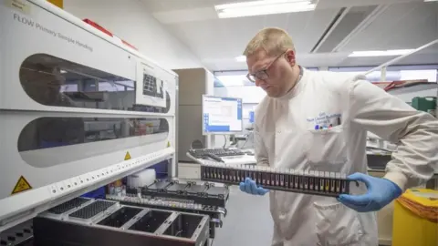PA Media Coronavirus testing laboratory: Clinical support technician Douglas Condie extracts viruses from swab samples
