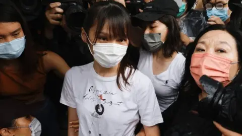 Reuters Agnes Chow (centre) leaves prison in Hong Kong. Photo: 12 June 2021