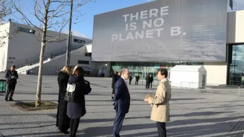 AFP/Getty Images People stand outside La Seine Musicale venue in Boulogne-Billancourt, west of Paris during the One Planet Summit. Photo: 12 December 2017