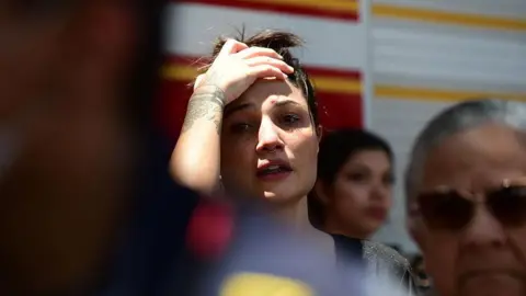 A woman holds her head in despair.