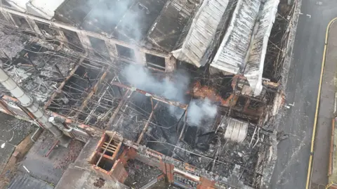 Shaun Whitmore/BBC Smoke coming off of a derelict building which has been damaged from a fire. The picture has been taken above by a drone.