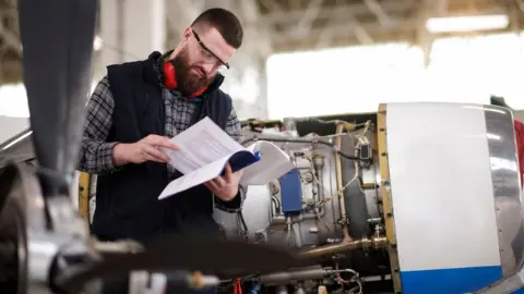 Getty Images An aerospace engineer reads an instruction manual