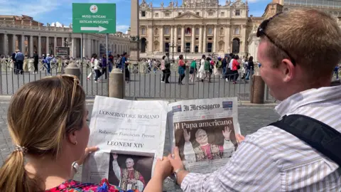 Tourists with newspapers in the Vatican