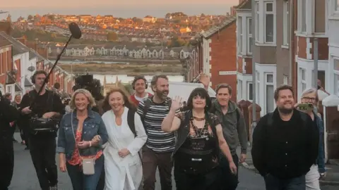 Shelli Cordner Joanna Page, Melanie Walters, Robert Wilfort, Ruth Jones, Rob Brydon and James Corden on Trinity Street with the sunset in the background