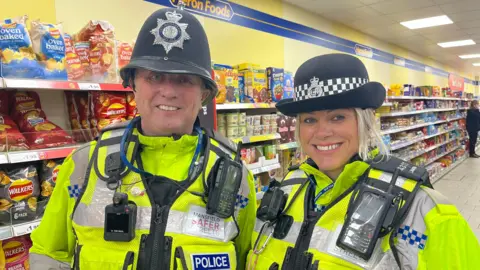 Two police officers in full uniform including radios and high vis jackets