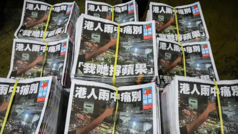 Getty Images Copies of the last Apple Daily newspaper are seen stacked in Hong Kong early on June 24, 2021.