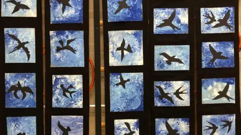 St Barnabas C of E Primary School A wall with multiple canvases of bird silhouettes 