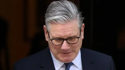 Sir Keir Starmer leaving Downing Street, with his head bowed