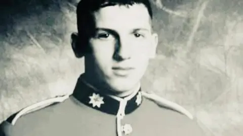 Family handout A black and white portrait photograph of Alan Forcer in his guard's full dress uniform.