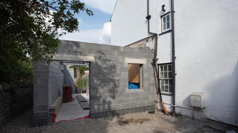 A stock image showing an extension being built on the side of a house