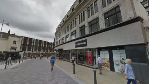 Google Binns House of Fraser on High Row in Darlington in the background, with shoppers in the foreground.