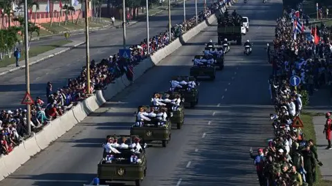 Getty Images Cubans line the streets in Havana on 15 January, to watch the funeral procession 