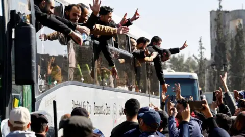 Reuters Freed Palestinian prisoners gesture from a bus in Khan Younis after being released by Israel as part of a hostages-prisoners swap, 15 February 2025.