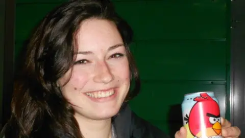 Ellie Rowe Ellie Rowe smiling holding a beer can with a bird on it
