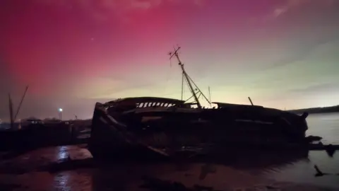 Dani_photograph83/BBC Weather Watchers A pink haze frames an overturned ship in Pin Mill, Suffolk.