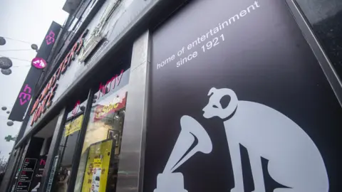 Getty Images A picture shows the signage on the front of a HMV store in central London on December 28, 2018. - British music retailer HMV, which was launched by English composer Edward Elgar in 1921, has collapsed into administration after weak Christmas sales and amid a declining market for CDs and DVDs, its owner said on December 28