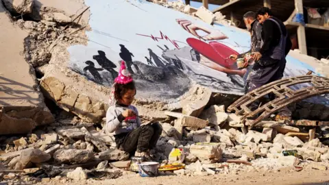 Getty Images Syrian graffiti artists paint the struggle of the earthquakes on the rubble of a collapsed building at Jindires, a district of Afrin, Syria - 22 February