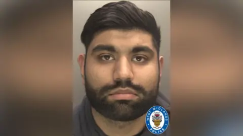 Aaron Kaninth - a custody image of a man with a short black mustache and beard, thick eyebrows and a straight black hair