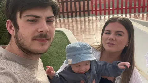 Family handout A young man and woman take a selfie with a baby