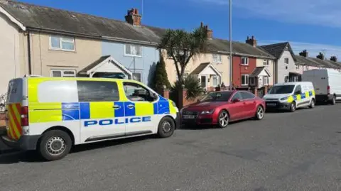 Andrew Turner/BBC Police vehicles outside a property on Admiralty Road, Great Yarmouth