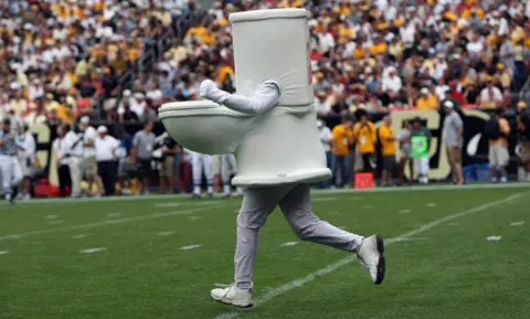 Getty Images A man dressed as a toilet runs onto the field during an American football game in Denver, Colorado