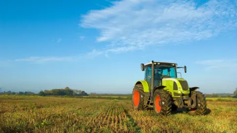 Getty Images A husbandman  driving a tractor successful  the UK. 