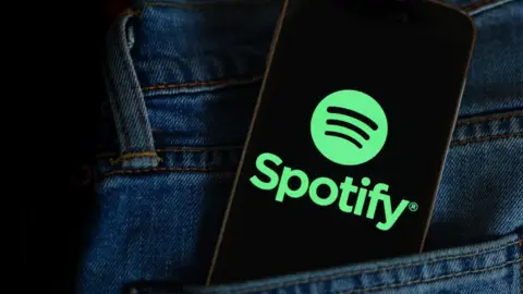 Getty Images Spotify logo on a phone in a pocket