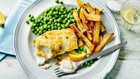 A plate of home-cooked fish, chips and peas