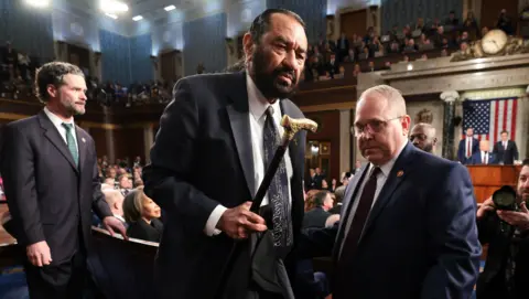 Democratic Congressman Al Green of Texas (C) is escorted out of the room after interrupting US President Donald Trump's address to a joint session of the United States Congress at the US Capitol in Washington, DC 