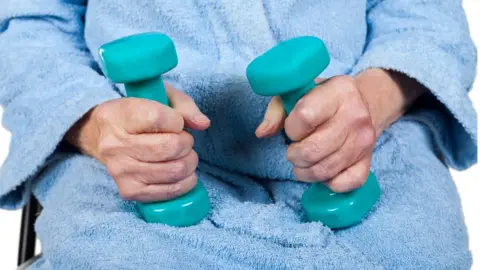 Getty Images Using dumbbell weights to exercise muscles