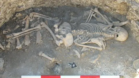 A human skeleton in the bottom of an archaeological pit