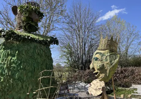 BBC/Andy Watson Two large puppets painted green are placed in the back garden of the Upfront Puppet theatre and museum in Penrith. 
