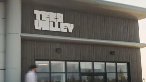 The headquarters of the Tees Valley Combined Authority, which is based at Teesside Airport. The entrance has wooden panels and a glass-fronted entrance.