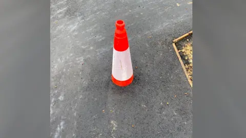 Ruth Whitehurst Orange and white plastic traffic cone
