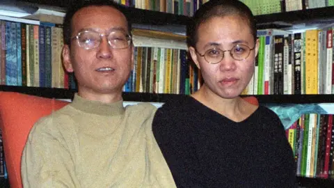 HANDOUT Liu Xiaobo and Liu Xia in front of a full bookcase