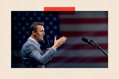 Getty Charlie Kirk addresses a crowd, with the American flag hanging in the background.