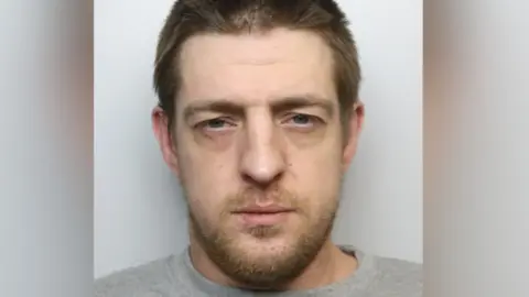 Robert Richens mugshot. He has short brown hair and scruffy brown stubble.