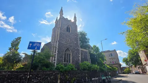 We can see the church on a sunny day, with three of the pinnacles on top of the tower visible.
