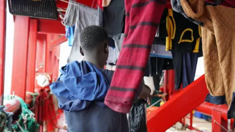 Migrant hangs up his washing to dry