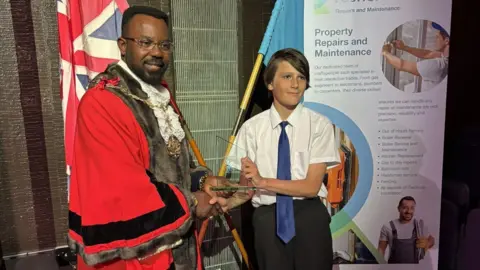 Family handout The mayor of Gravesham in Kent is presenting a community award to a local teenager at an awards night.