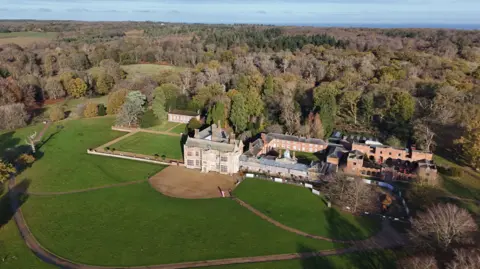 Shaun Whitmore/BBC An aerial image of Felbrigg Hall and its courtyard building, surrounded by trees and parklands.