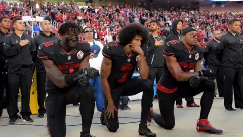 Reuters Eli Harold, Colin Kaepernick and Eric Reid (35) kneel in protest during the playing of the national anthem before a NFL game