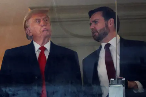 Reuters Donald Trump and JD Vance talk to each other behind a glass panel