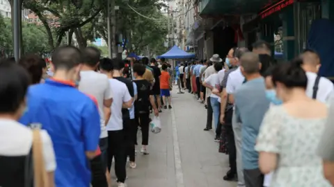 Getty Images People queue up for COVID-19 nucleic acid tests on July 12, 2022 in Lanzhou, Gansu Province of China.