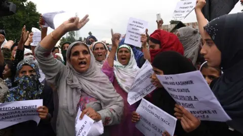 Getty Images Kashmiri protesters hold placards and shout slogans during a protest, at Soura, on August 16, 2019 in Srinagar