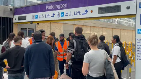A crowd of people outside the closed Elizabeth line entrance at Paddington station