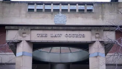 The facade of Sheffield Crown Court. Large metal lettering reads "The Law Courts".