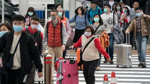 Getty Images A group of Chinese tourists walks outside the arrival lobby at Narita airport on January 24, 2020 in Narita, Japan.